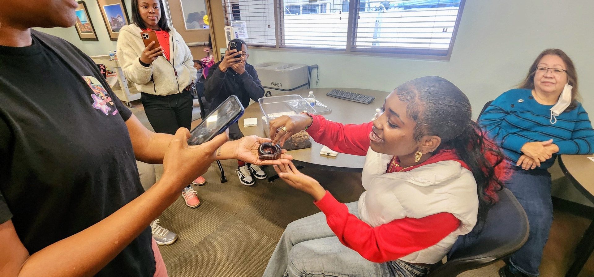 CJ introducing a millipede to a curious participant while others watch.