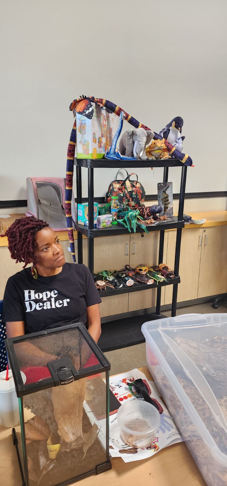 CJ with her All My Creatures setup — terrariums, plush animals, and educational supplies ready for a visit.